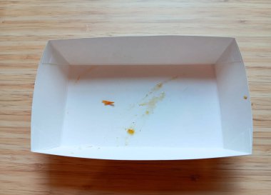 Tahta arka planda izole edilmiş öğle yemeğinden sonra boş beyaz kraft yiyecek kutusu. Geri dönüşüm kavramı.