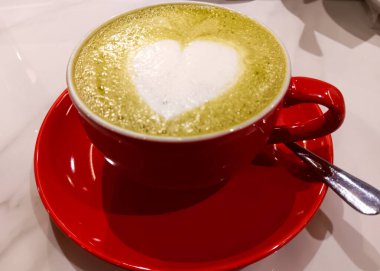 Kırmızı bardakta sıcak kibrit sütlü kahve beyaz arka planda izole edilmiş..