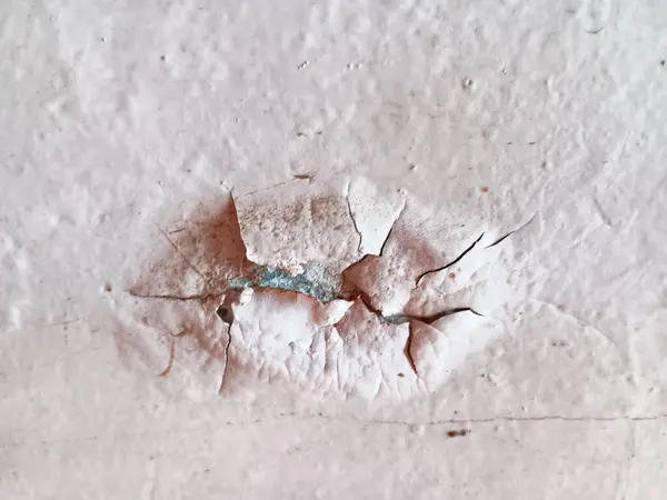 Duvardaki beyaz boyayı soymaya ve kırmaya yakın, nem yüzünden hasar görmüş..