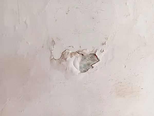 Duvardaki beyaz boyayı soymaya ve kırmaya yakın, nem yüzünden hasar görmüş..