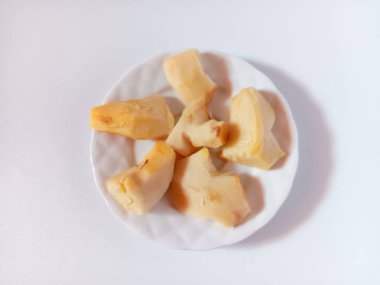 Close up of fresh peeled and cut ginger in a plate isolated on white background.