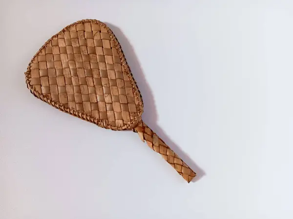 Mini kahverengi örülmüş bambu yelpazesi beyaz arkaplanda izole edilmiş..