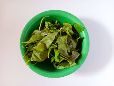 Plastik kasedeki taze organik yeşil ıspanak yaprakları beyaz arka planda izole edilmiş..