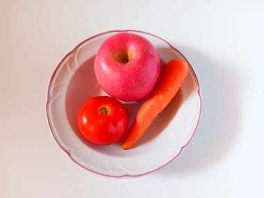 Elma, havuç, beyaz arka planda izole edilmiş domates tabağı. Sağlıklı bir içki. Sağlıklı yaşam kavramı.