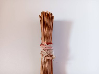 Süpürge sapı, beyaz arka planda izole edilmiş birçok tahta çubuktan yapılmış bir süpürgedir. Endonezya 'da kullanışlı bir araç..