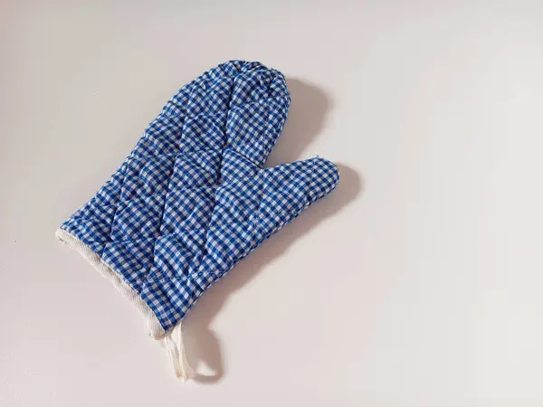 Mavi kareli fırın eldiveni, beyaz arka planda izole edilmiş sıcak yemek takımlarını tutarken elleri ısıdan korumak için mutfak eldivenleri..