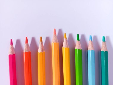 Beyaz arkaplanda sıralı renkli kalemleri, renkli kalemleri, kurşun kalemleri veya renkli kalemleri kapat.