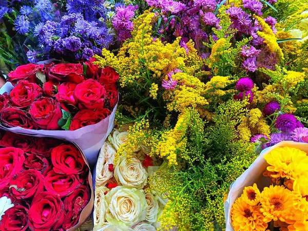 Gül, Kasımpatı Morifolium, Aster amellus, Avrupalı Michaemas papatyası ve Solidago namı diğer bir çiçekçide satılık altın buketler gibi renkli çiçek buketleri..