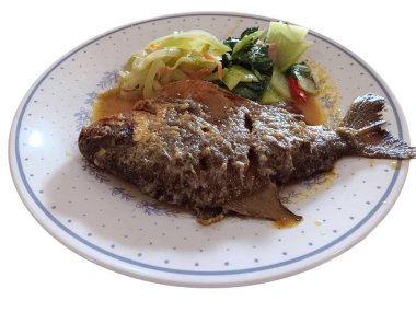 Endonezya yemeği, zerdeçal soslu kızarmış pomfret, beyaz arka planda izole bir tabakta kızarmış chayote ve pak choi. Sağlıklı gıda konsepti.