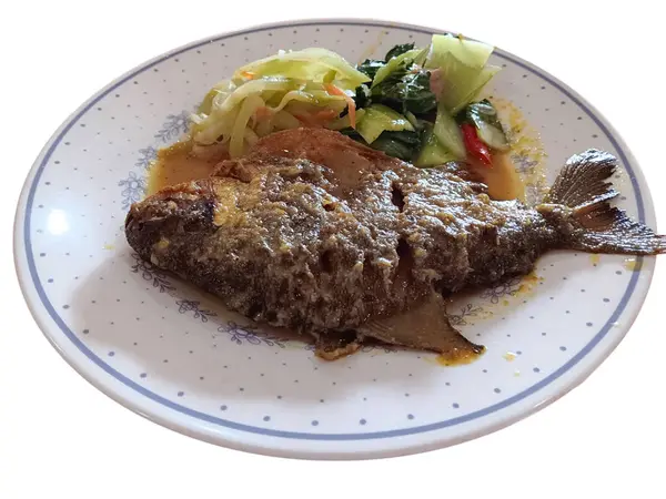 Endonezya yemeği, zerdeçal soslu kızarmış pomfret, beyaz arka planda izole bir tabakta kızarmış chayote ve pak choi. Sağlıklı gıda konsepti.