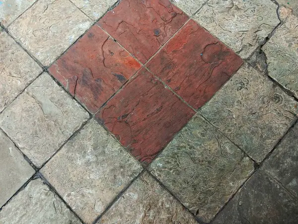 Kırmızı ve gri damgalı beton kare taş döşeme arka planı. Üst görünüm.