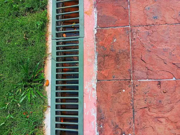 Gri metal ızgara borusu ya da parktaki siper drenaj sistemi. Üst görünüm.