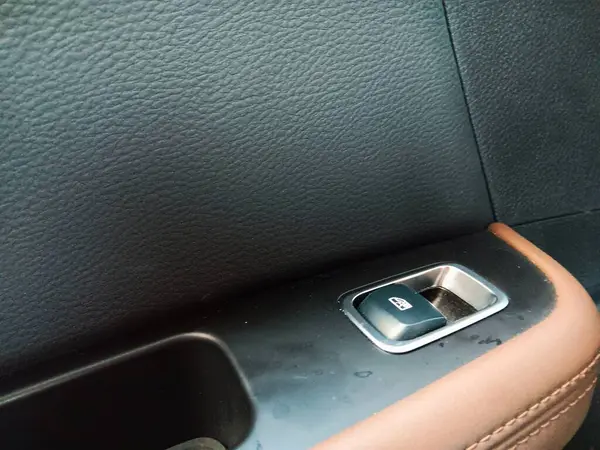 Kapının panelinde siyah kapı süslemesi olan arabanın güç düğmesi. Yolcu koltuğu.