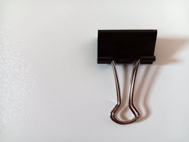 Siyah metal ataç, ataç, kağıt kıskacı, banker atacı veya foldover olarak da bilinir. Beyaz arkaplanda izole edilmiş. Metin için alanı kopyala.