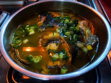 Sarı çorbada gümüş yayın balığı paslanmaz çelik kasede pişirilir..