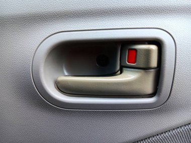 Sürücü koltuğundaki bir arabanın kırmızı manuel kapı kilidi kolu..