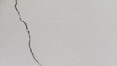 Gri bir duvardaki dikey çatlakların soyut dokusu.