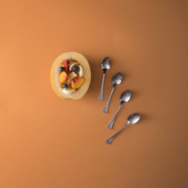 Pastel arka planda kaşıklarla dilimlenmiş yaz meyveleri konsepti. Düz konum.