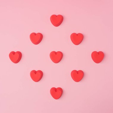 Kırmızı kalpler şablonu, romantik konsept, üst manzara. Pastel pembe arka planda kalp şeklinde kek kutuları olan güzel bir konsept. Sevgililer Günü tebrik kartı. Düz bir estetik..