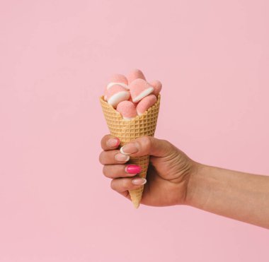 Pastel Backgroun 'da pembe şekerli dondurma külahı, tatil konsepti sanatı..