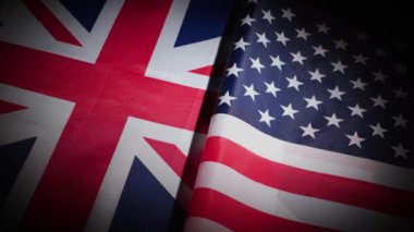 Birleşik Devletler ve Büyük Britanya 'nın bayrakları karanlık arka planda döner tablolarda. Yüksek kalite 4k görüntü