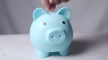 3 tanesi mavi kumbara tasarruf konseptine beyaz arka plana para koyuyor. Yüksek kalite 4k görüntü