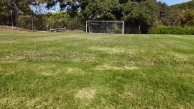 Futbol kalesi mavi gökyüzünün altında yeşillik ve açık alanla çevrili. Yüksek kalite 4k görüntü