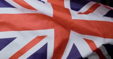 Bu video, İngiliz bayrağının açık mavi gökyüzüne karşı sallanışını gösteriyor. Ulusal gurur ve İngiliz mirasını temsil ediyor.