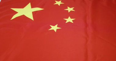 Bu video, sarı yıldızlı canlı bir kırmızı bayrak içeriyor. Ayrıntıları vurgulayan geniş ve yakın plan çekimler yoluyla birlik ve kimlik gösteriyor.