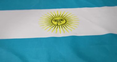 Video, mavi, beyaz ve sarı güneş motifli canlı bir bayrağı vurguluyor. Dönüşüm geçirir, yorumları ortaya çıkarır, kültürel önemini vurgular.