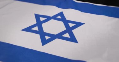 Bu videoda Davut Yıldızı 'nın kültürel önemini ve mirasını vurgulayan yakın çekimler içeren mavi ve beyaz bir bayrak sergileniyor.