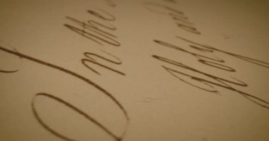 Bu video, el yazısıyla yazılmış bir notun yakın plan çekimlerini sergiliyor. Kağıt dokusunu ve yazının önemini vurguluyor.