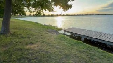 17 Sunset Light Yansıyan Lakeside Rıhtımı ve Gölgeli Ağaçlar. Yüksek kalite 4k görüntü