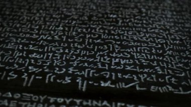 Bu video antik ve modern iletişimi inceliyor, bir bilgisayar ekranı ile Yunan yazılarının karatahtasını karşılaştırarak, edebi önemi vurguluyor