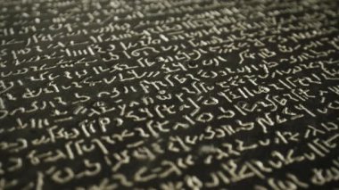 Bu video, karmaşık Arapça kaligrafisi olan, senaryonun güzelliğini ve becerisini gösteren, eğitim ve geleneği çağrıştıran bir karatahta içeriyor.