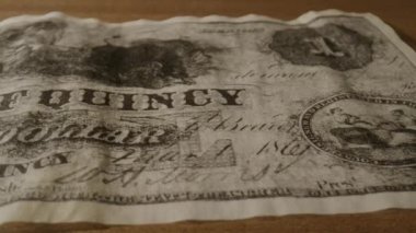 Bu video, beş dolarlık banknotun klasik bir fotoğrafı ve bir dolarlık banknota dönüşmesiyle başlayan çeşitli dolar banknotlarını gösteriyor.