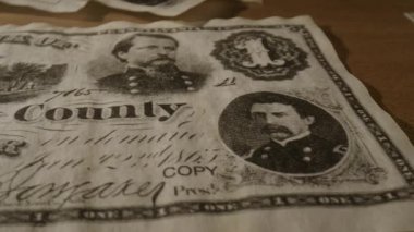 Bu video yerel para biriminin tarihini ve sanatını derinlemesine inceliyor, eşsiz dolar banknotlarını ve portrelerini sergiliyor, işçiliğini vurguluyor