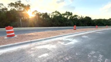 Gün ışığı, huzurlu bir yol kenarındaki yemyeşil ağaçların arasından süzülür. Bu huzurlu ortamda güzel bir ışık ve gölge etkileşimi yaratır.