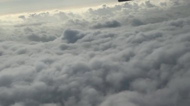 Bir uçak penceresinden uçsuz bucaksız, bulutlu gökyüzünün çarpıcı hava manzarasının tadını çıkarın. Bu video kayan bulutların sakin atmosferini yakalar.