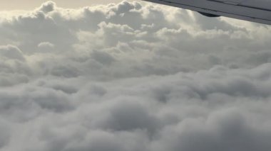 Bir uçak penceresinden bulutların sakin hava manzarasının tadını çıkar. Yüksek kalite 4k görüntü