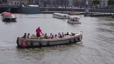 Arkadaşların yeşilliklerle çevrili pitoresk bir nehirde manzaralı bir tekne yolculuğunun keyfini çıkarırken heyecan verici bir macera gözler önüne seriliyor ve neşeli bir atmosfer yaratıyor.