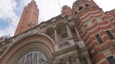 Bu video klasik sütunları ve kemerleri olan kırmızı tuğlalı bir bina, zarif bir saat kulesi ve bulutlu bir gökyüzü, tarihi mimariyi gözler önüne seriyor.