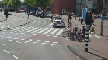 Amsterdam, Hollanda 29 Temmuz 2025: Araba bisikletçileri ve trafik ışıklarıyla Amsterdam şehir kavşağı