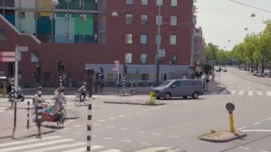 Amsterdam, Hollanda 29 Temmuz 2025: Caddede bisikletli kırmızı tuğlalı köşe binası