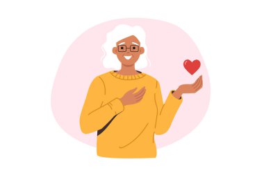 Nazik yaşlı kadın kalbi elinde tutuyor ve ekranlara bakıp gülümsüyor, şefkat ve sevgi istiyor. Yaşlı kadın, yaşlıların yaşam süresini artırmak için yapılan bağışların önemini hatırlatıyor..
