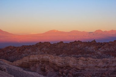 Atacama Çölü 'nün aşınmış kaya taşları arasında turuncu gün batımı