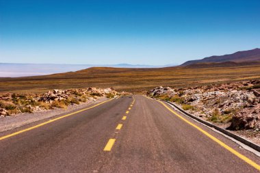 Dağlar ve Atacama çölleri arasındaki ıssız yolda çok sakin bir günde çok fazla ışık var.