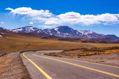 Arka planda görülebilen karlı dağlar arasındaki lagünlerden geçen yollar.