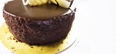 Kurabiyelerle süslenmiş çikolatalı pasta ve beyaz arka planda çikolatalar. Kahverengi doğum günü pastasının düzlüğü