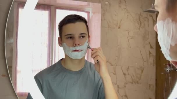 Έφηβος Ξυρίζεται Ξυράφι Μπροστά Στον Καθρέφτη Του Μπάνιου — Αρχείο Βίντεο